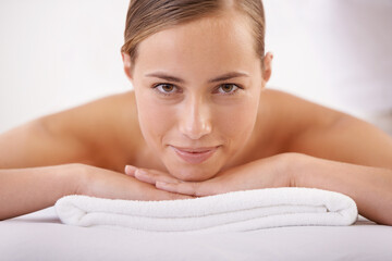 Massage, smile and portrait of woman on table for luxury, treatment and pamper with peace in hotel...