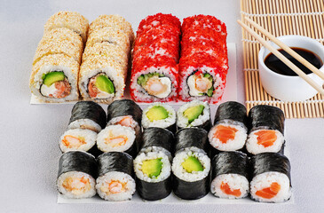 Popular types of sushi, soy sauce and chopsticks. Set of sushi roll on a gray background.