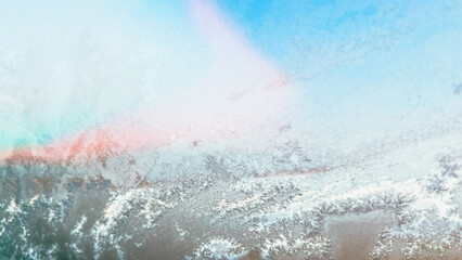 Abstract background with hoar frost on window on frosty sunny day. Defocused ice layer on blue...