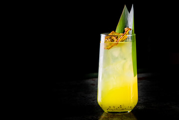 Glass with tropical juice lemonafe with fruits on table