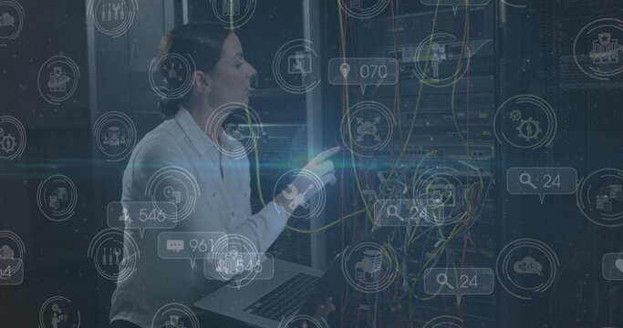 Image of falling icons over caucasian female server room worker - Powered by Adobe