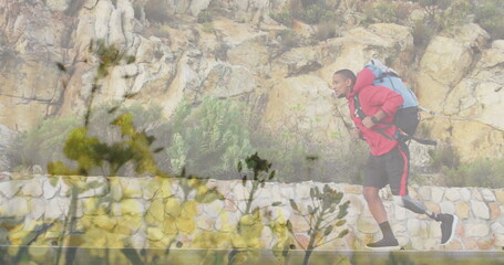 Image of flowers over disabled african american man with artificial leg hiking