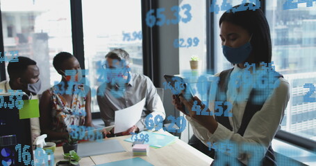 Image of financial data processing over diverse business people in face masks in office