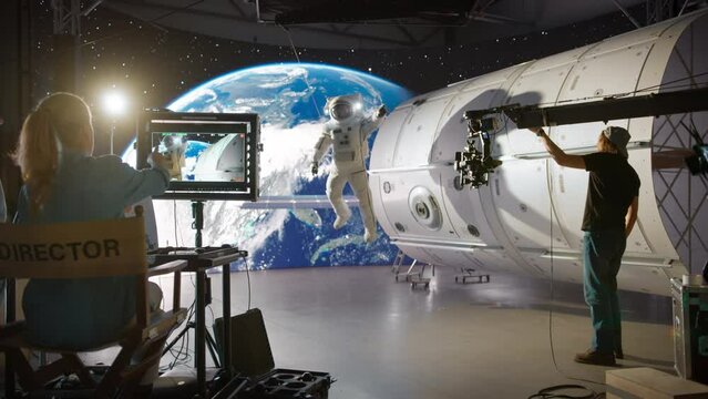Creative Agency Filming a Video Commercial with an Actor Wearing an Astronaut Costume and is Floating in Outer Space. Backstage From a Virtual Production Studio with Director and Cameraman at Work 