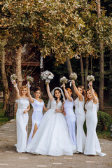 Wedding photography. A brunette bride in a white dress with a bouquet and her brunette girlfriends