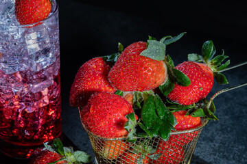  a basket brimming with ripe strawberries paired with a strawberry cocktail in a glass, resting on...