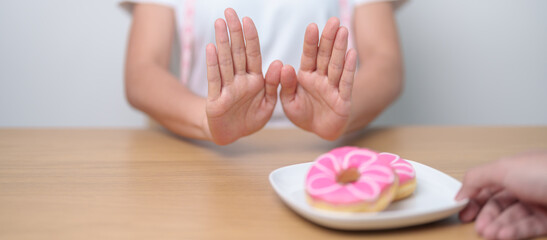 woman hand reject donut dessert, female refuse Unhealthy junk food. Dieting control, Weight loss, Obesity, eating lifestyle and nutrition concepts - obrazy, fototapety, plakaty