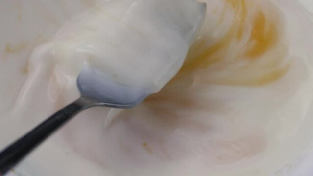close-up with a fork in a plate, mixing milk with egg, slow motion. preparing breakfast milk with egg yolk. homemade dough