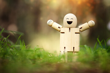 Wooden figure in nature with smiling face. Concept of joy happiness and wellness