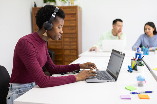 African woman focuses on work in a collaborative office space