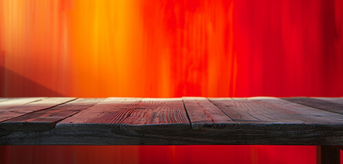 A wooden table set against a blurred backdrop transitioning from red to orange