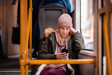 Fototapeta na wymiar Relaxed Young Woman Smiling on City Bus with Smart Phone