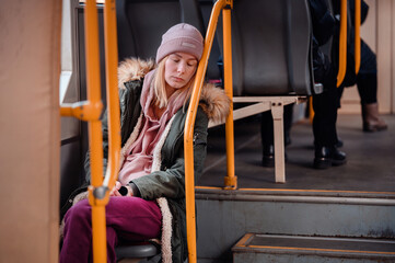 Fototapeta na wymiar Contemplative Young Woman Resting Head on Hand in City Bus