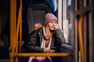 Relaxed Young Woman Smiling on City Bus with Smart Phone