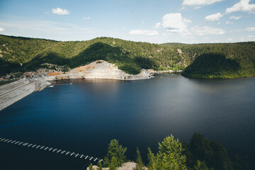 Obraz premium A serene lake embraced by towering mountains and lush trees