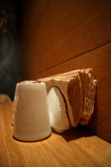 There is a set of white saltshaker and tissue holder on a brown classy table great lightning