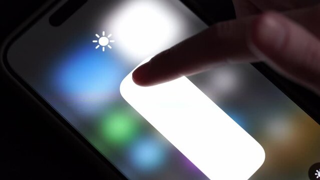 Dnepr, Ukraine - 09.12.2023: Adjusting screen brightness on iPhone. Setting up your phone.