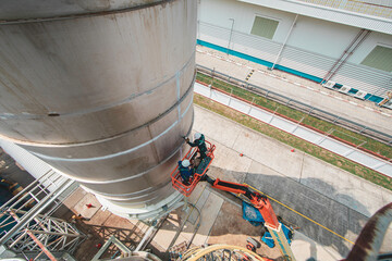 Male industry working at high in a boom liftinspection tank silo © chitsanupong