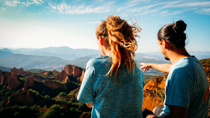 Two young people at sunset looking out over a mountain landscape.
Las Medulas natural park in spain