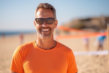 portrait of smiling man in sunglasses standing on beach with volleyball net