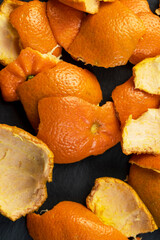 a large number of orange citrus fruits on a black slate surface