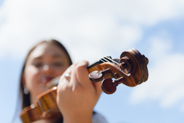 blurred portrait of woman standing with violin outdoors