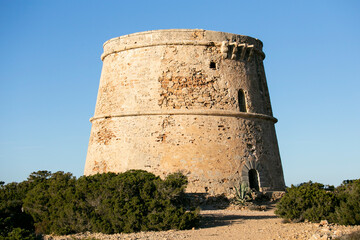 Fototapeta na wymiar The Torre d'en Rovira is located in front of the western islets between the beaches of Comte and Cala Bassa on the island of Ibiza.
