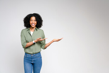 A dynamic African-American woman points with confidence, her joyful expression and casual business...