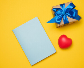 Notepad and gift box on yellow background
