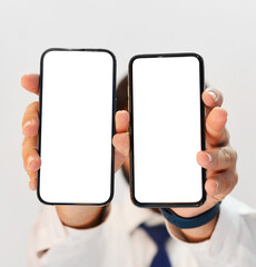 Person Holding Two Mobile Screens with Empty White Space to place anything. Smartphone comparison concept screens background