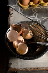 Cracked eggshells and whisk on the table, space for text
