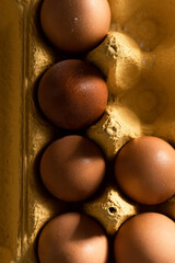 Close up view of brown eggs in yellow paper box
- 741462683