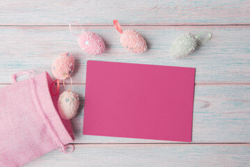Decorative Easter eggs with a blank pink card, set against a pastel wooden background - 741463264