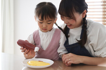 オムレツにケチャップをかける親子