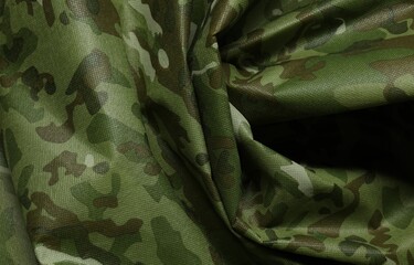 Texture of crumpled camouflage fabric as background, top view