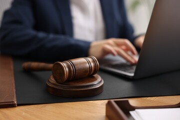 Notary working with laptop at table, focus on gavel - obrazy, fototapety, plakaty