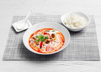 Tom yam soup with seafood, mushrooms, tomatoes, peppers and rice. Asia food.