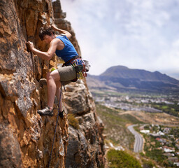 Rock climbing, woman and fitness with adventure, challenge and gear to explore in nature on...