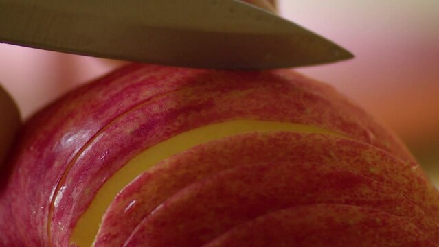 Close-up of apple being sliced with knife