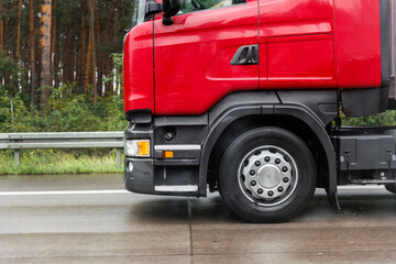 Close-up semi-trailer truck wheel driving fast Splashing Water on Highway, Risk of Aquaplaning on Wet Road. Detail view of hydroplane danger on rainy asphalt surface. Weather conditions.