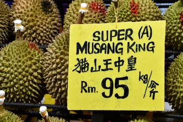 Foto op Plexiglas Delicious juicy fleshy aromatic Malaysian durians sold by fruit stalls in night market, Bukit Bintang, Kuala Lumpur, Malaysia. King of fruits in Southeast Asia with pungent smell but savoury taste. © Yafe