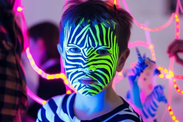 Rolgordijnen child with neon face paint like zebra stripes at a party © studioworkstock
