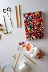 Various craft supplies on white background. Supplies for jewelry making, drawing and needlework. Flat lay.