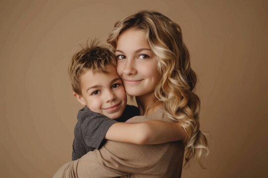 Mother hugging her son, Mother's Day concept, beige background.