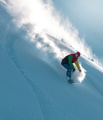 Snowboarding Powder Snow. A snowboarder making a powder turn on a piste covered with fresh snow on a sunny morning