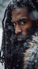 A man with dreadlocks standing in the snow