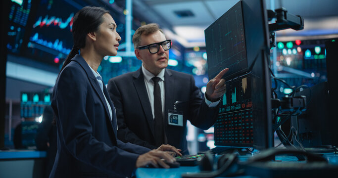 Routine Work Day in an International Stock Exchange Hall: Multiethnic Specialists Monitoring Equity and Share Markets on a Computer, Working on Maximizing Profits for Corporate Business Partners