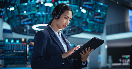 Portrait of a Young Beautiful Stock Exchange Broker Using Tablet Computer, Researching Real-Time Stocks Data, Analyzing Commodities and Exchange Market Charts. Professional Investment Banker in Office