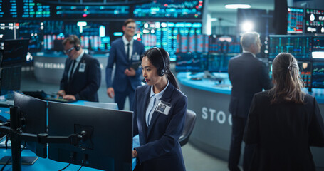 Female Stock Exchange Banker Working on a Desktop Computer with Real-Time Stocks, Commodities and...