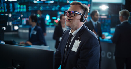 Portrait of Professional Middle Aged Trader Working on a Stock Exchange. Stylish Adult Man Communicating Buy and Sell Orders on a Call and Showing Hand Signals to an Arbitrage Broker - obrazy, fototapety, plakaty